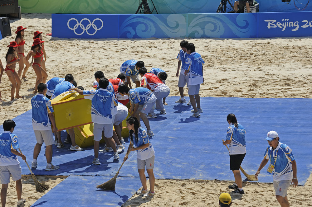 Set up podium, sweep away sand for medal ceremony