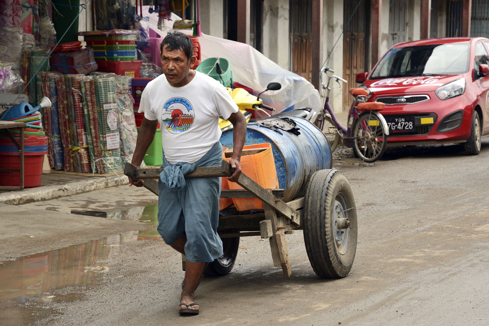 Transporting drum of water through the streets